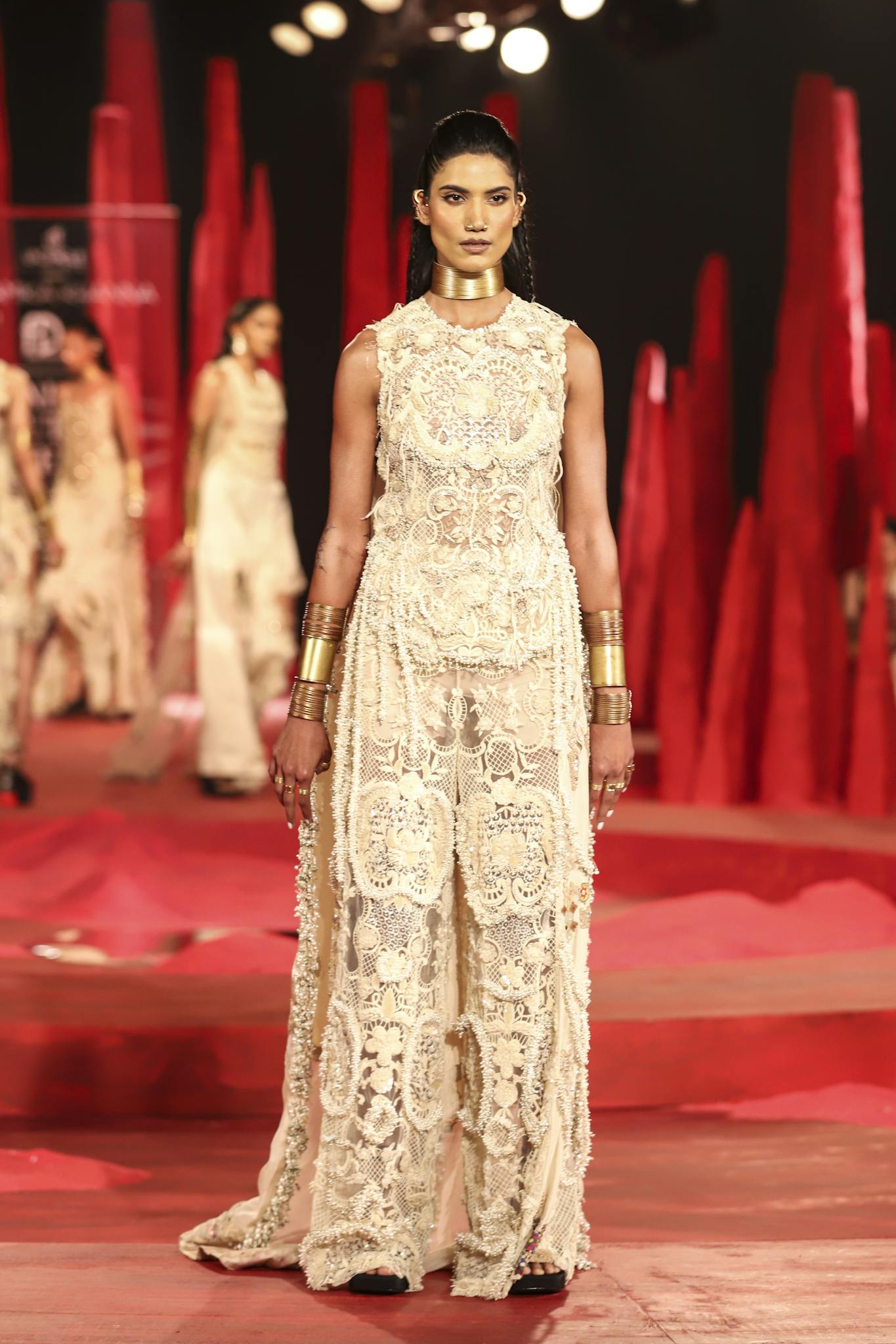 Model wearing an intricate lace dress on the runway, showcasing contemporary fashion in New Delhi.