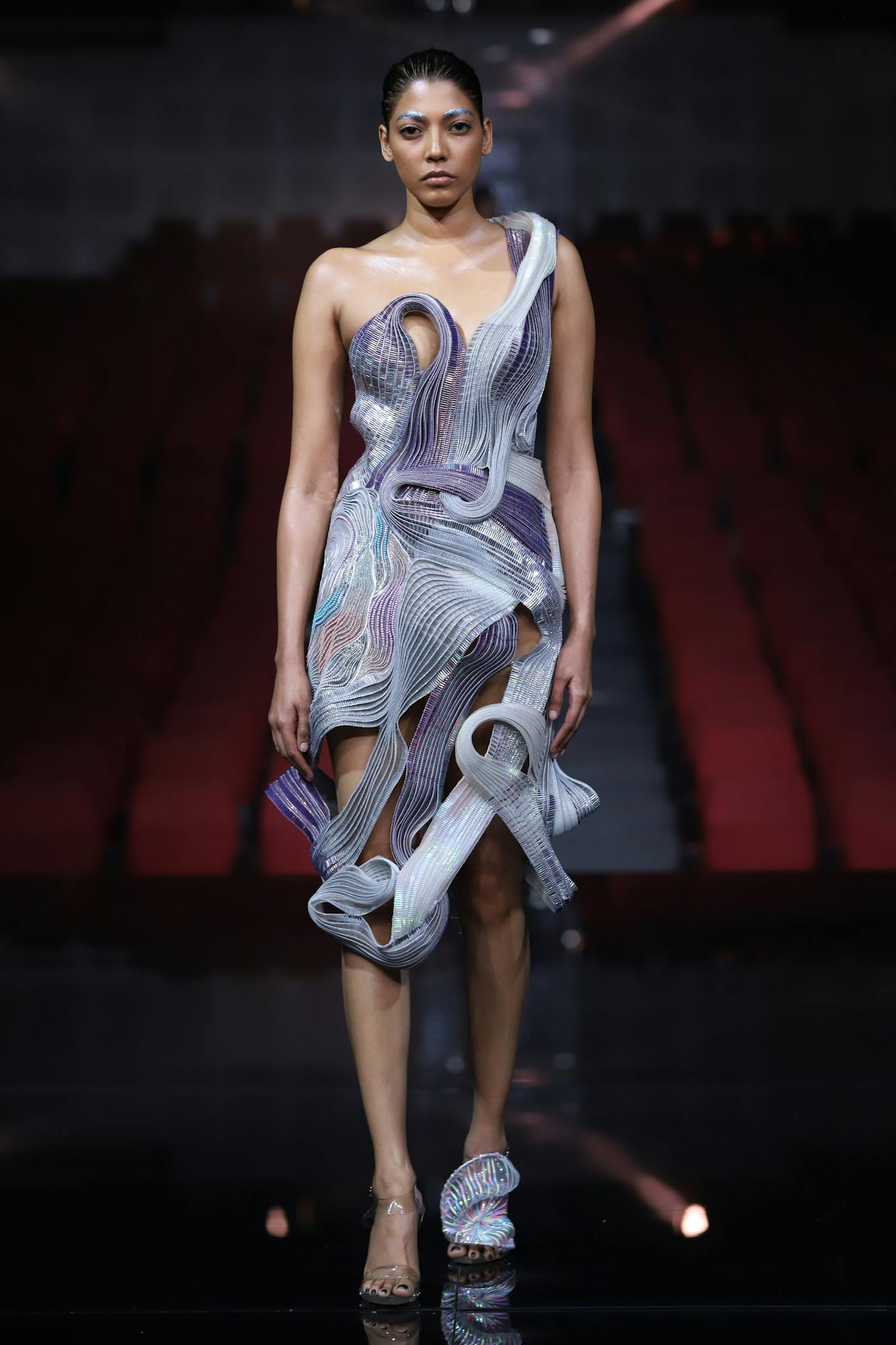 Striking fashion model in avant-garde dress captured during a runway show in New Delhi.